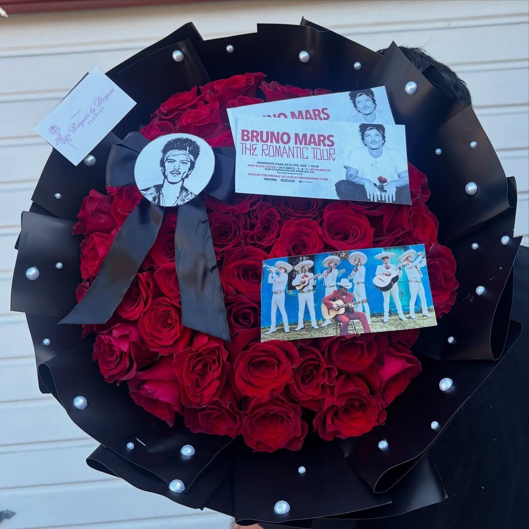 Bouquet of red roses with Bruno Mars photos and concert ticket in black wrap