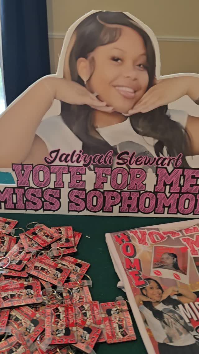 Campaign materials including a large cardboard cutout and keychains for Miss Sophomore election.