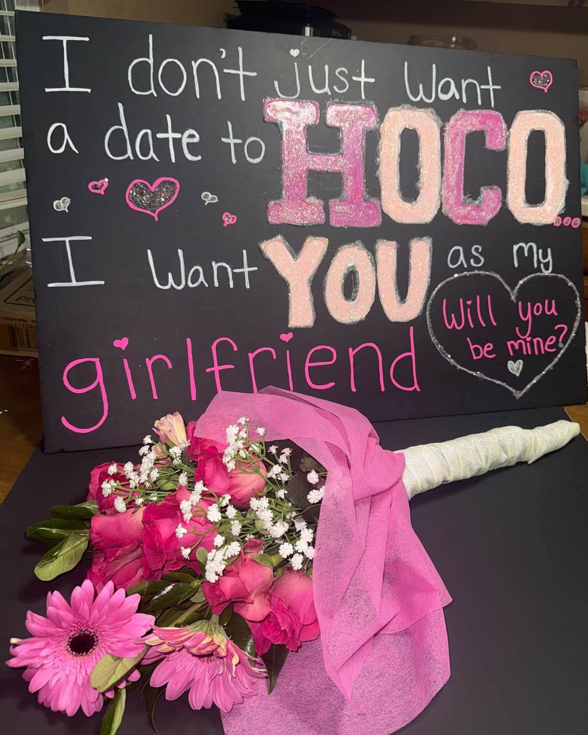 Homecoming proposal poster with pink lettering and a matching pink flower bouquet.