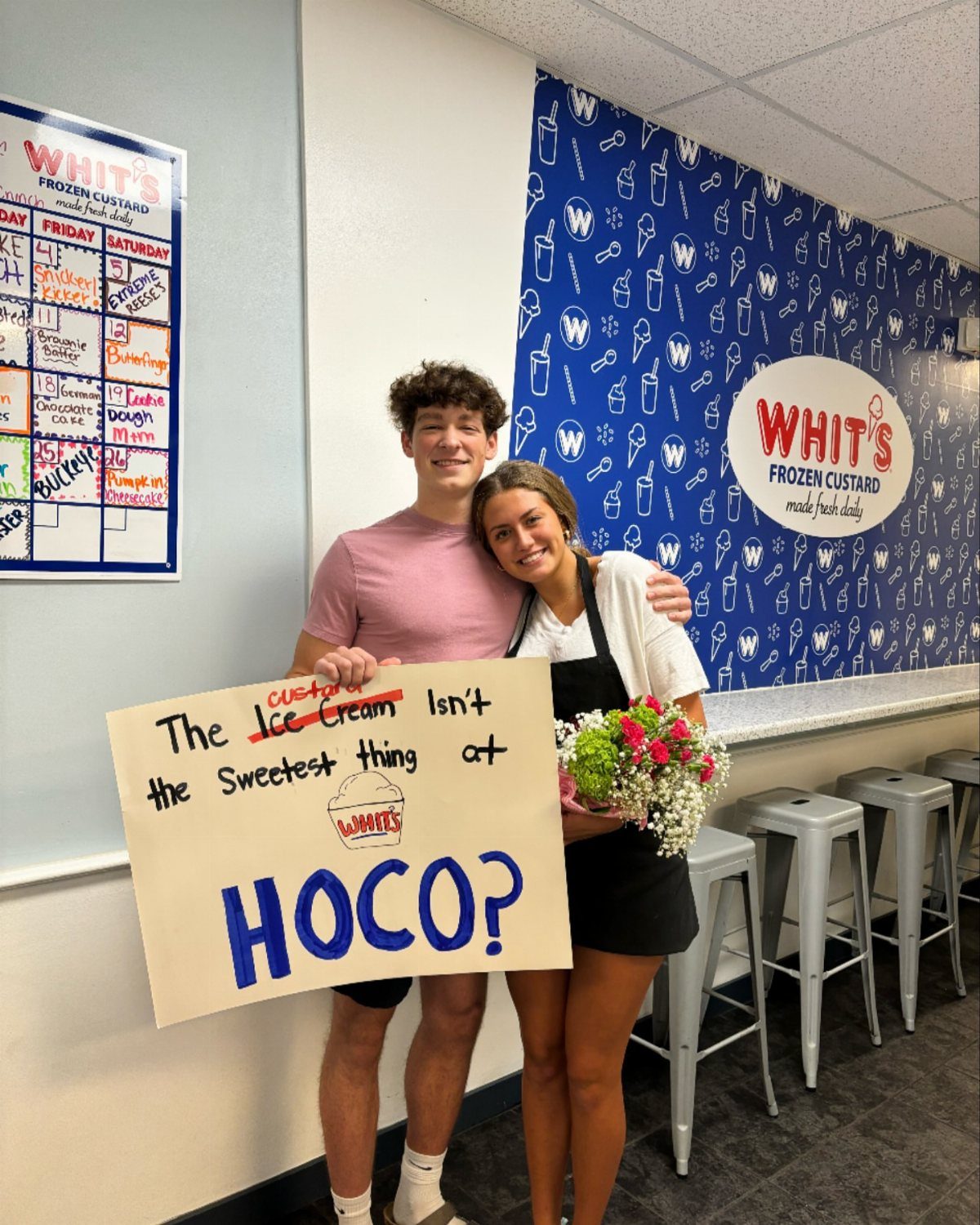 Teenage couple posing in an ice cream shop with a homecoming proposal sign