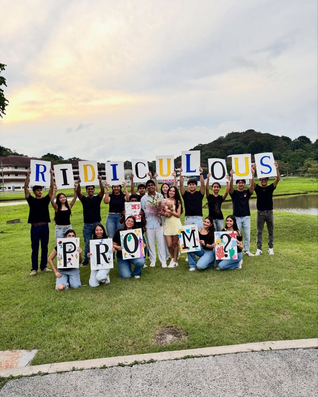 Group of teenagers holding signs that spell out RIDICULOUS PROM? on a lawn
