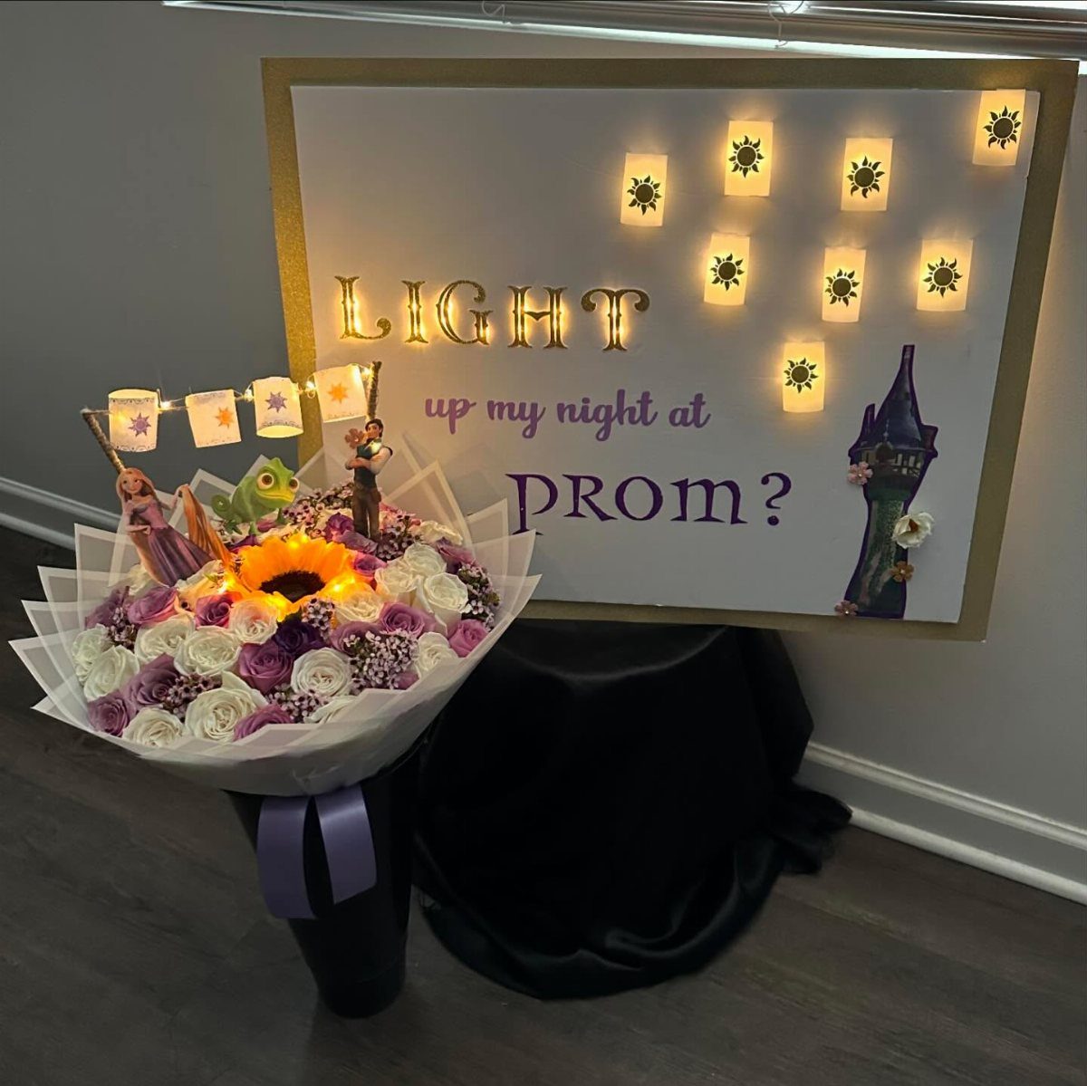 Prom proposal sign with glowing lanterns and a large purple and white rose bouquet