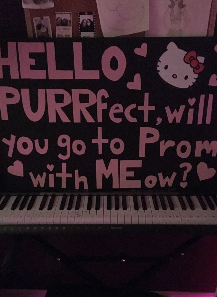Black promposal poster with pink Hello Kitty theme resting on a piano keyboard