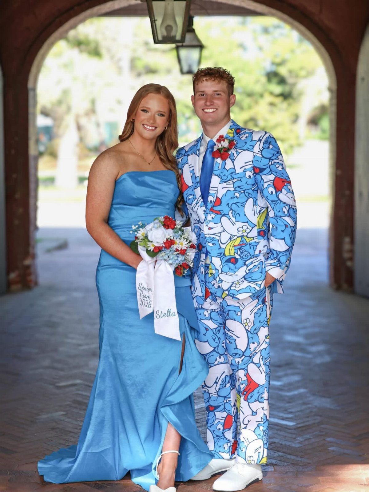 Couple posing for prom, woman in blue dress, man in Donald Duck suit.
