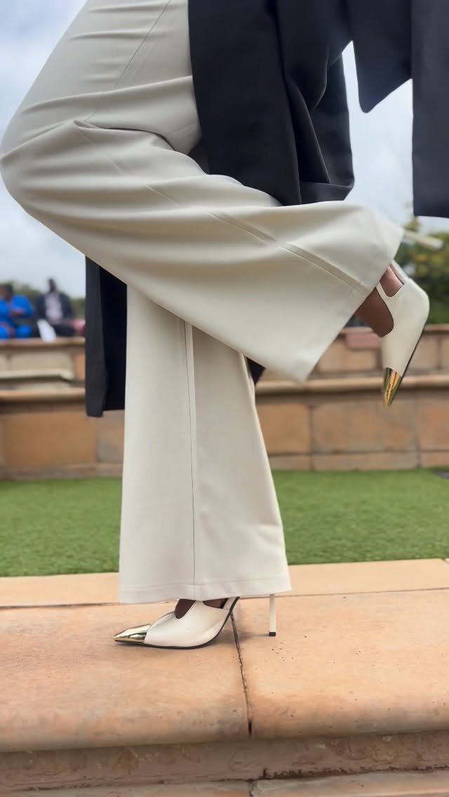 White wide-leg trousers and gold-tipped white heels paired with a black blazer.