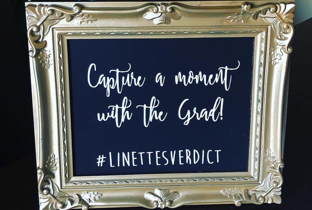 Gold ornate frame with a blue sign inviting guests to photograph the graduate.