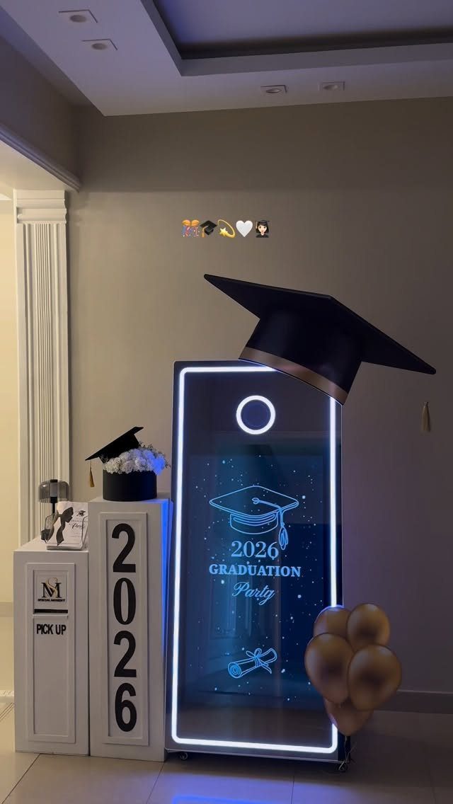 Digital graduation photo booth mirror decorated with a mortarboard cap and gold balloons.
