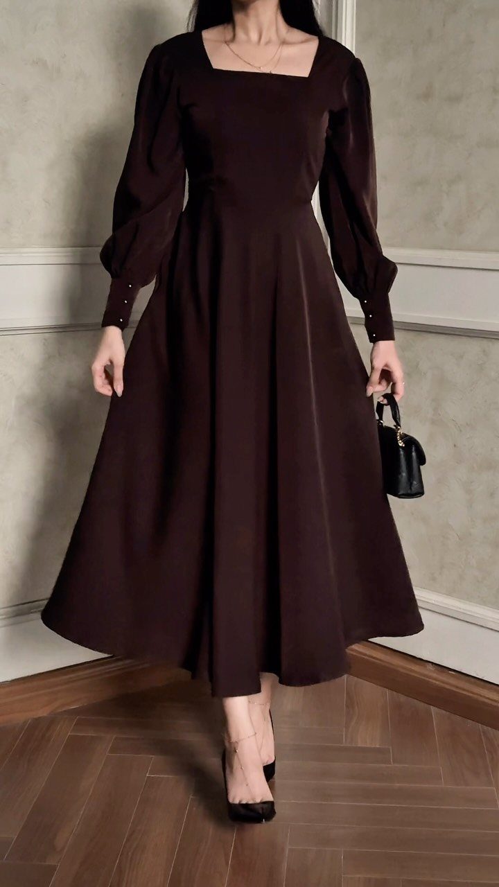 Person in a dark brown fitted dress with black heels and handbag.