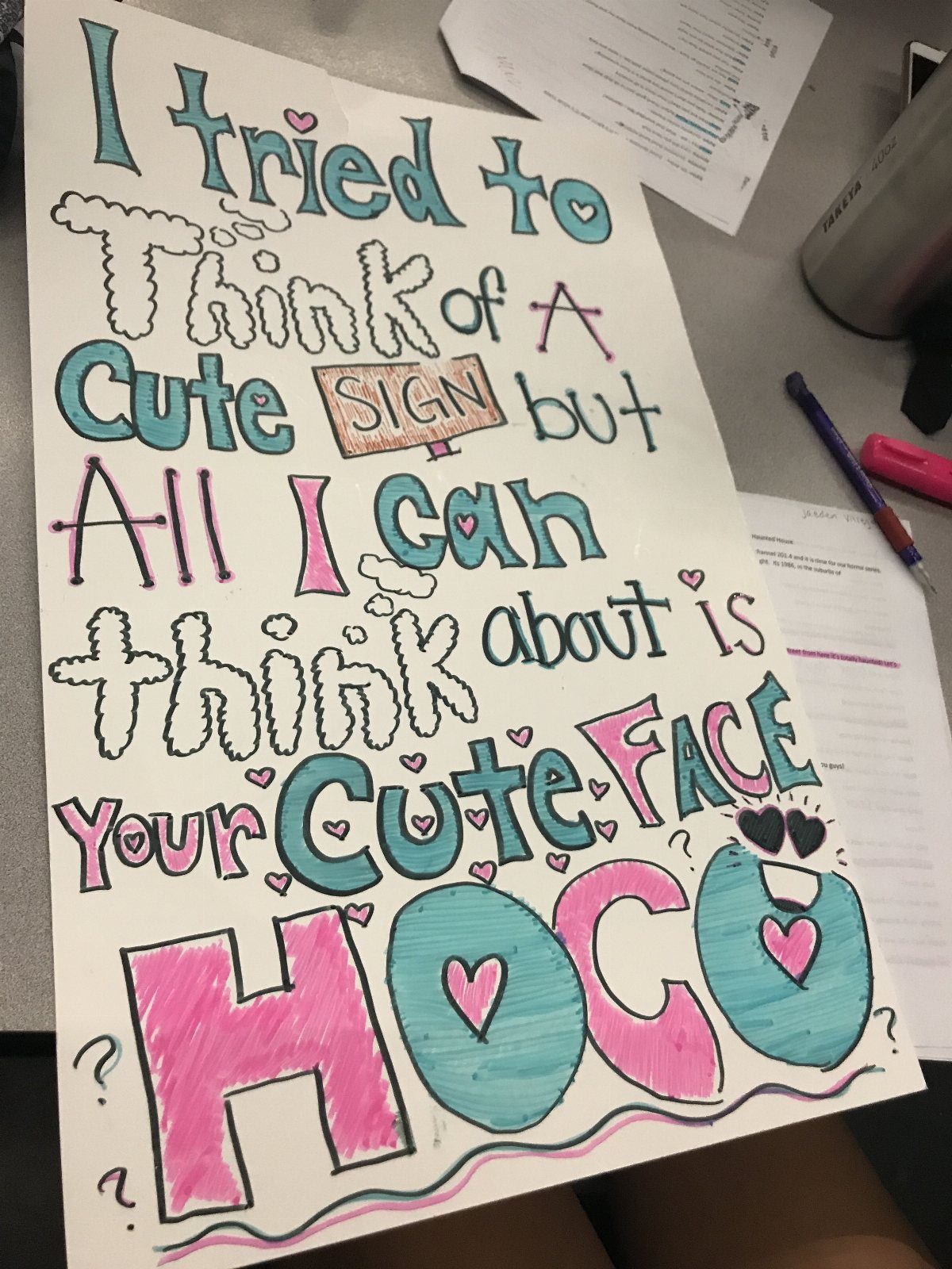 Hand-drawn homecoming proposal poster with colorful bubble letters and heart decorations on paper.