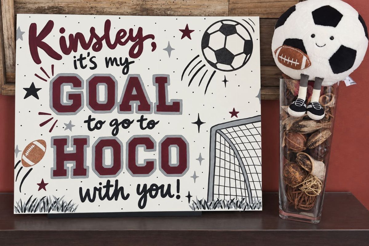 Soccer themed homecoming proposal poster with a plush soccer ball in a vase