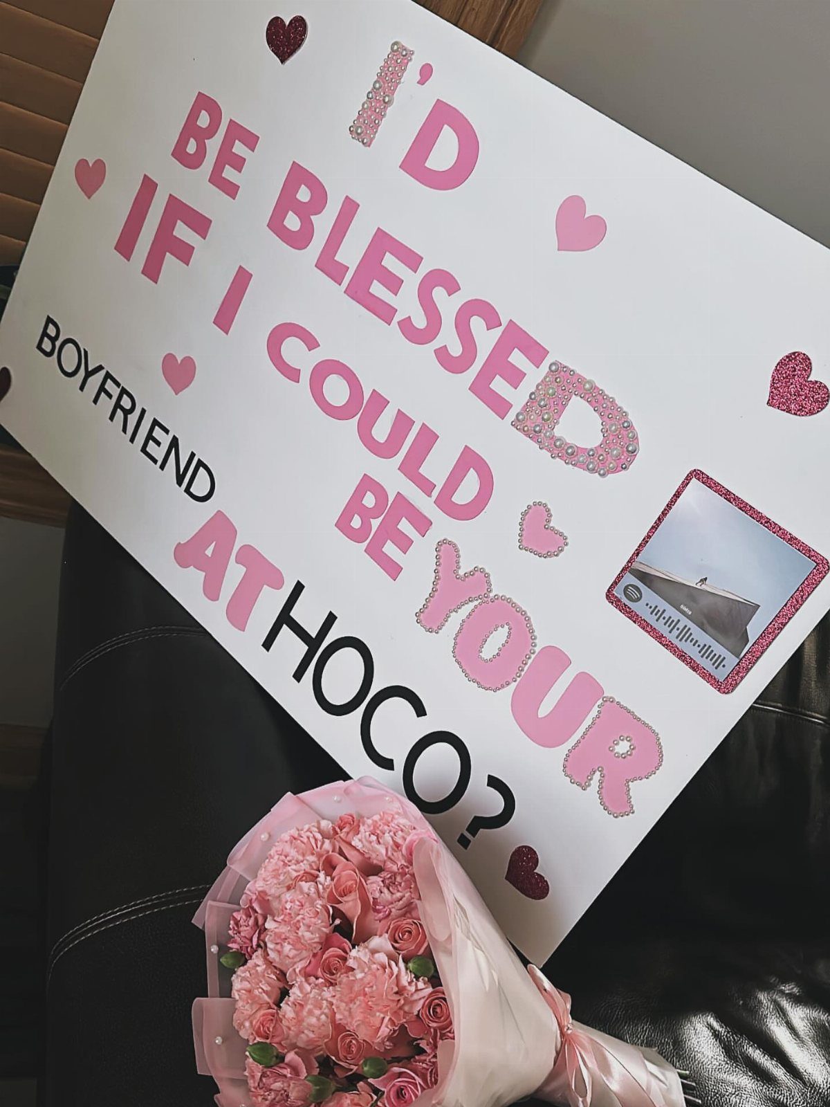 Homecoming proposal poster with pink text and hearts next to pink carnations