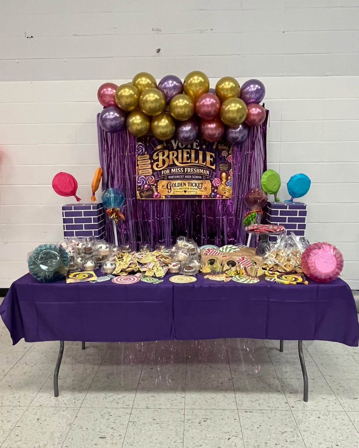 Purple and gold homecoming campaign display with balloons and a nominee poster.