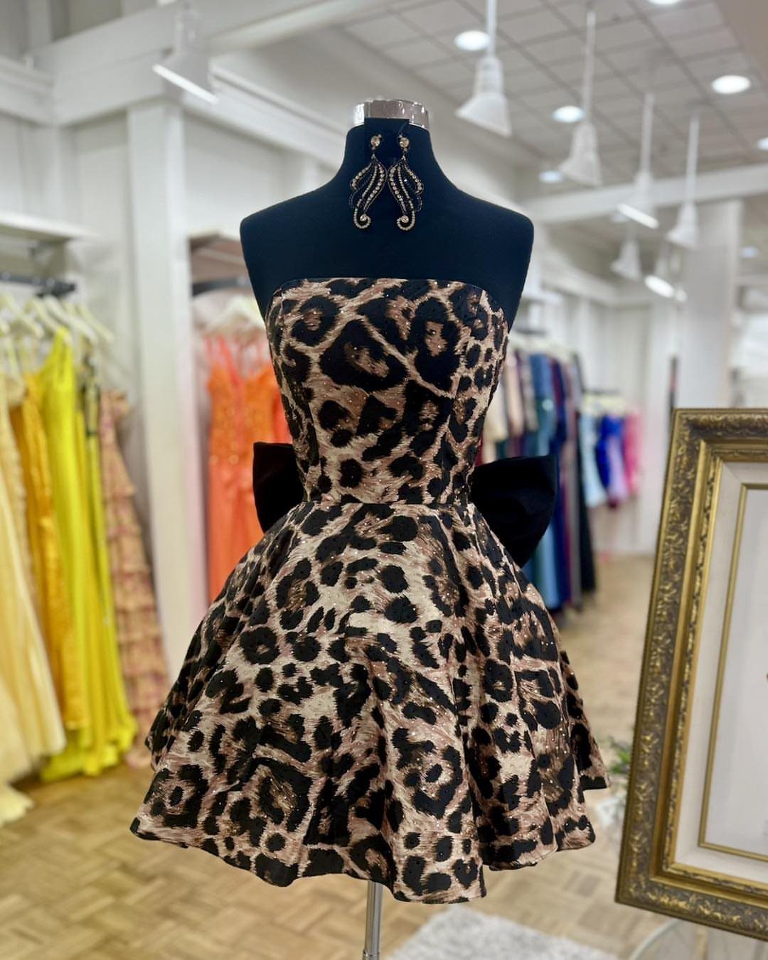Leopard print short strapless dress with black bow on a black mannequin