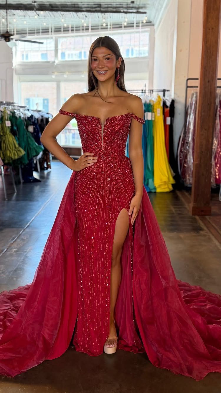 Woman in a long red sequined off-the-shoulder gown with a high leg slit