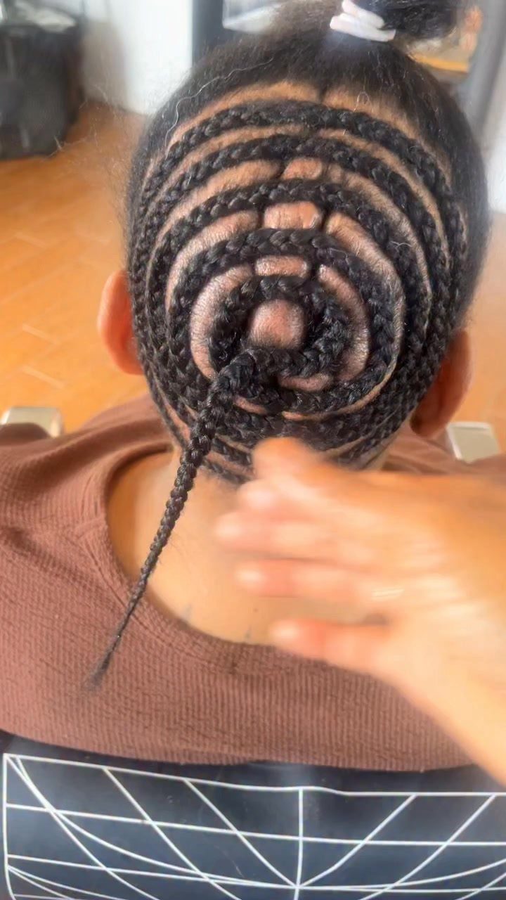Black hair braided in a concentric circular pattern on the back of a head.