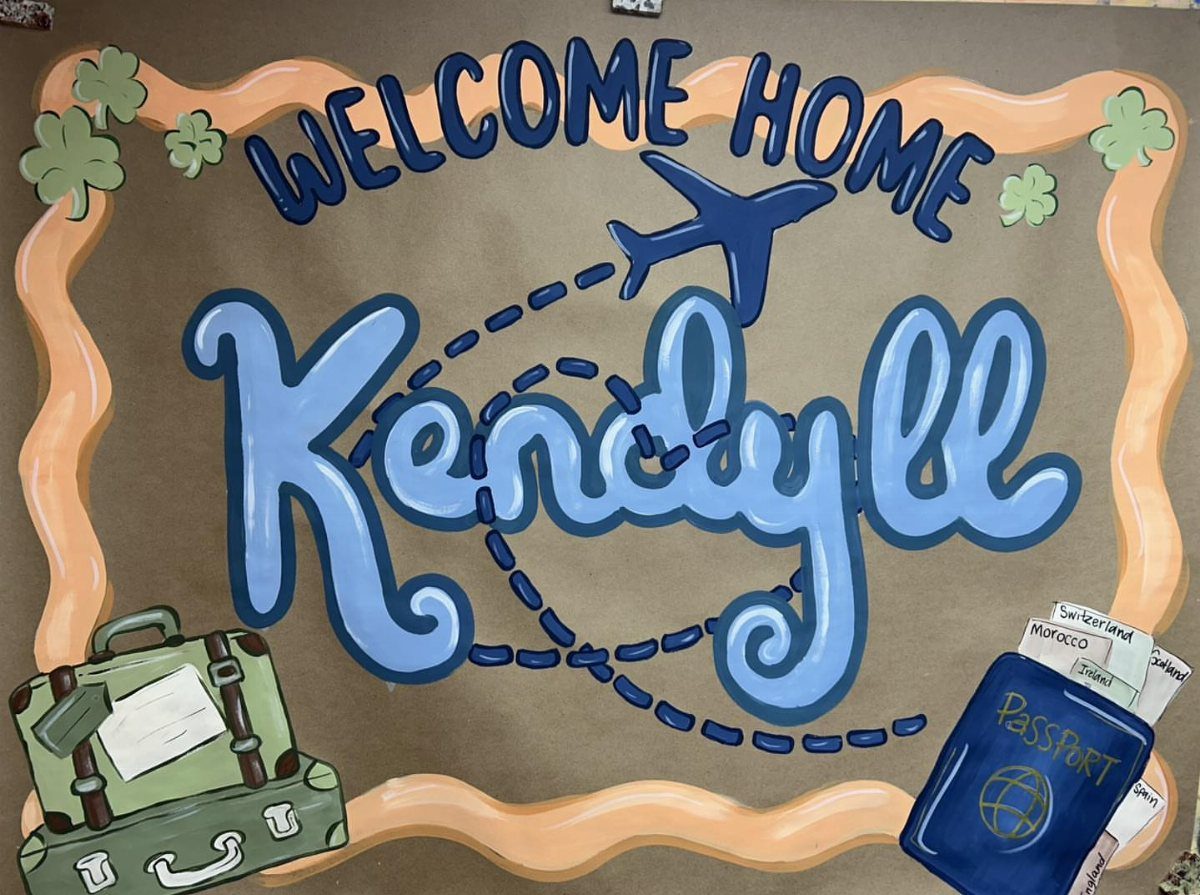 Travel themed welcome home poster with airplane, suitcase, and passport illustrations.