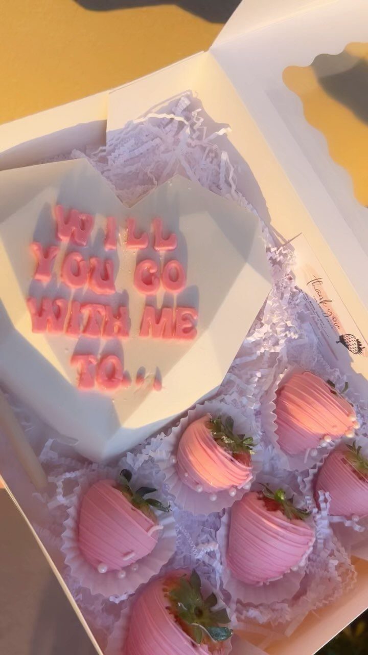 Pink chocolate-covered strawberries and a heart-shaped chocolate plaque with a proposal message.