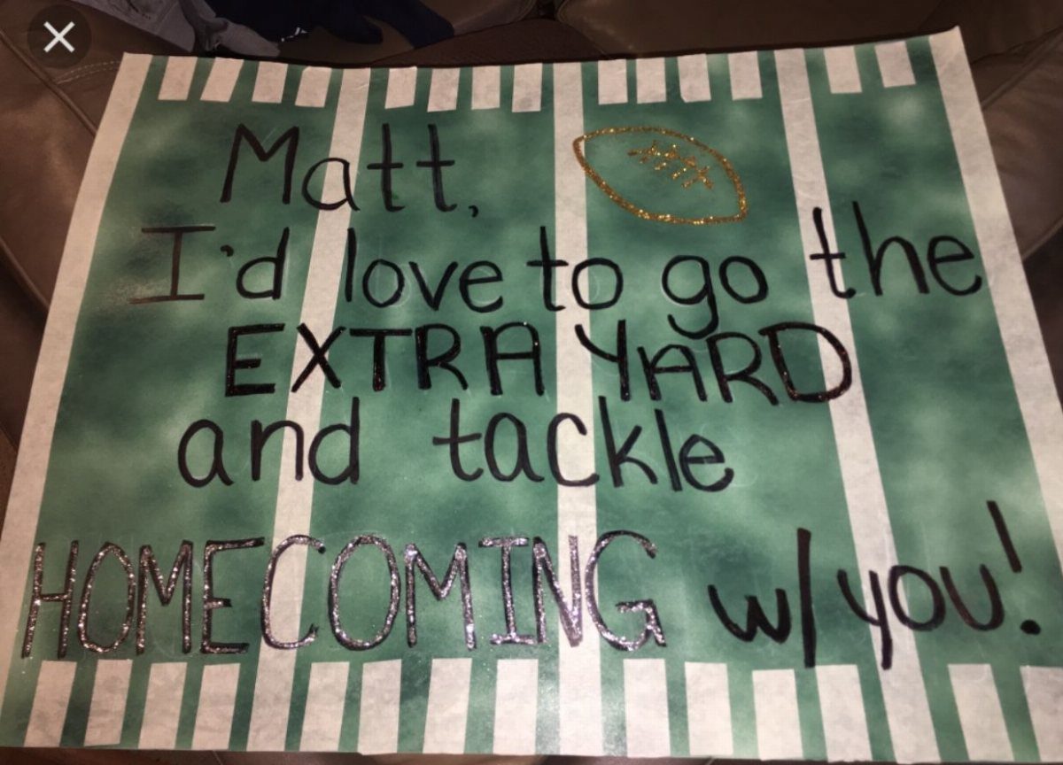 Handmade homecoming proposal poster with football puns and green striped background.
