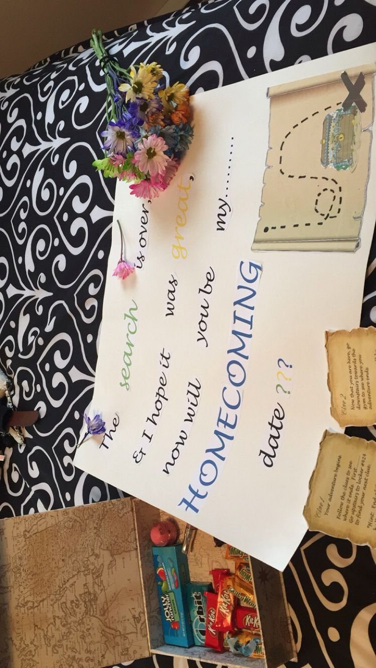 Homecoming proposal sign with a treasure map, colorful flowers, and a box of candy.