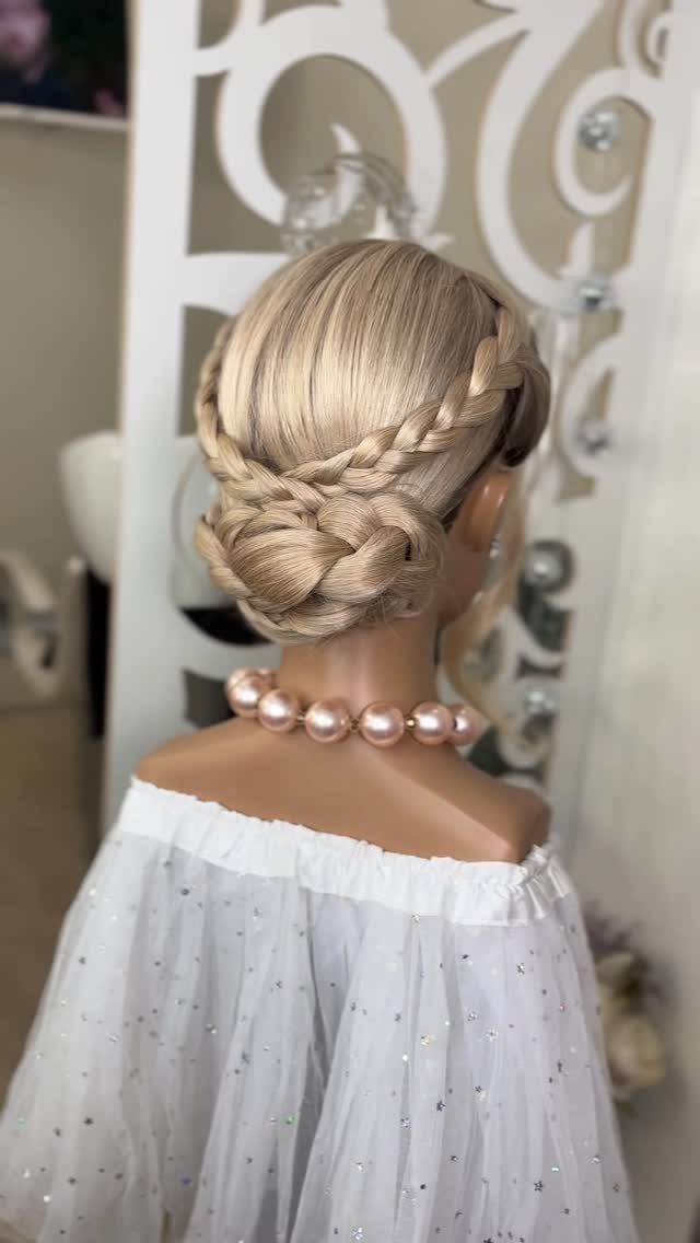 Blonde braided crown hairstyle transitioning into a low bun on a mannequin.