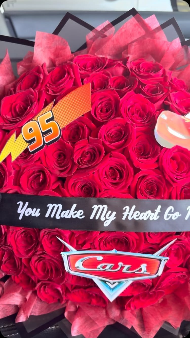 Red rose bouquet with Lightning McQueen 95 and Cars movie logo decorations.