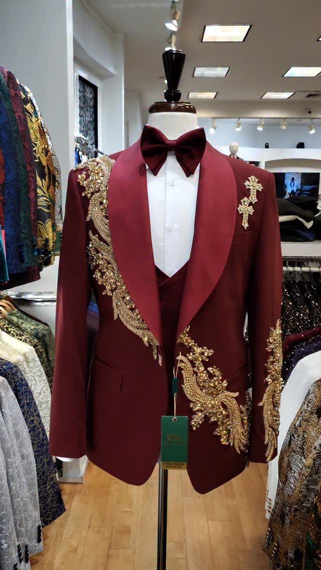 Burgundy suit with gold embroidery and bow tie displayed on a mannequin.