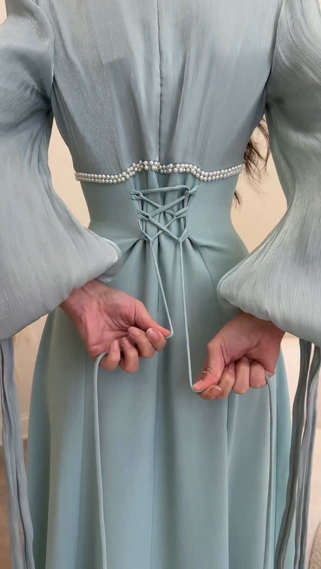 Light blue gown with a pearl-beaded waist and lace-up corset back detail.