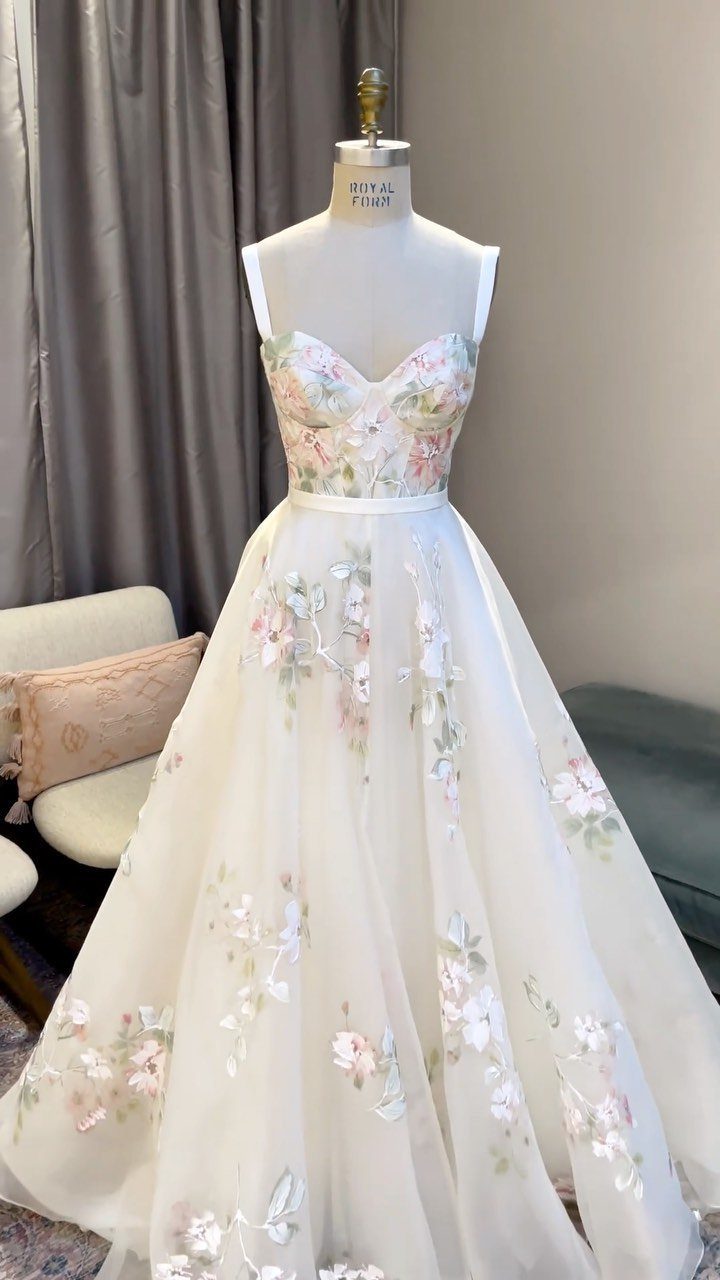 White ball gown with floral embroidery displayed on a white dress mannequin