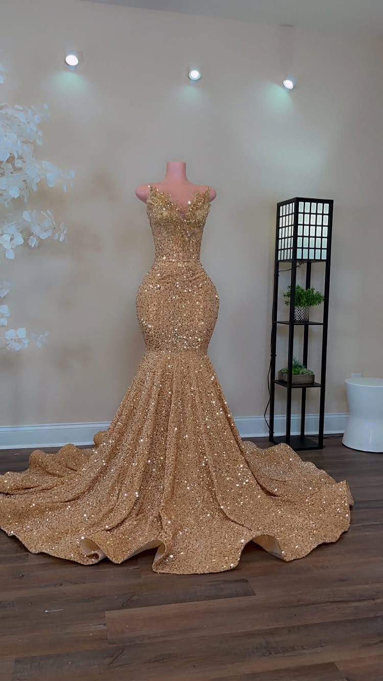 Gold sequined mermaid prom dress on a mannequin with a long flared train.