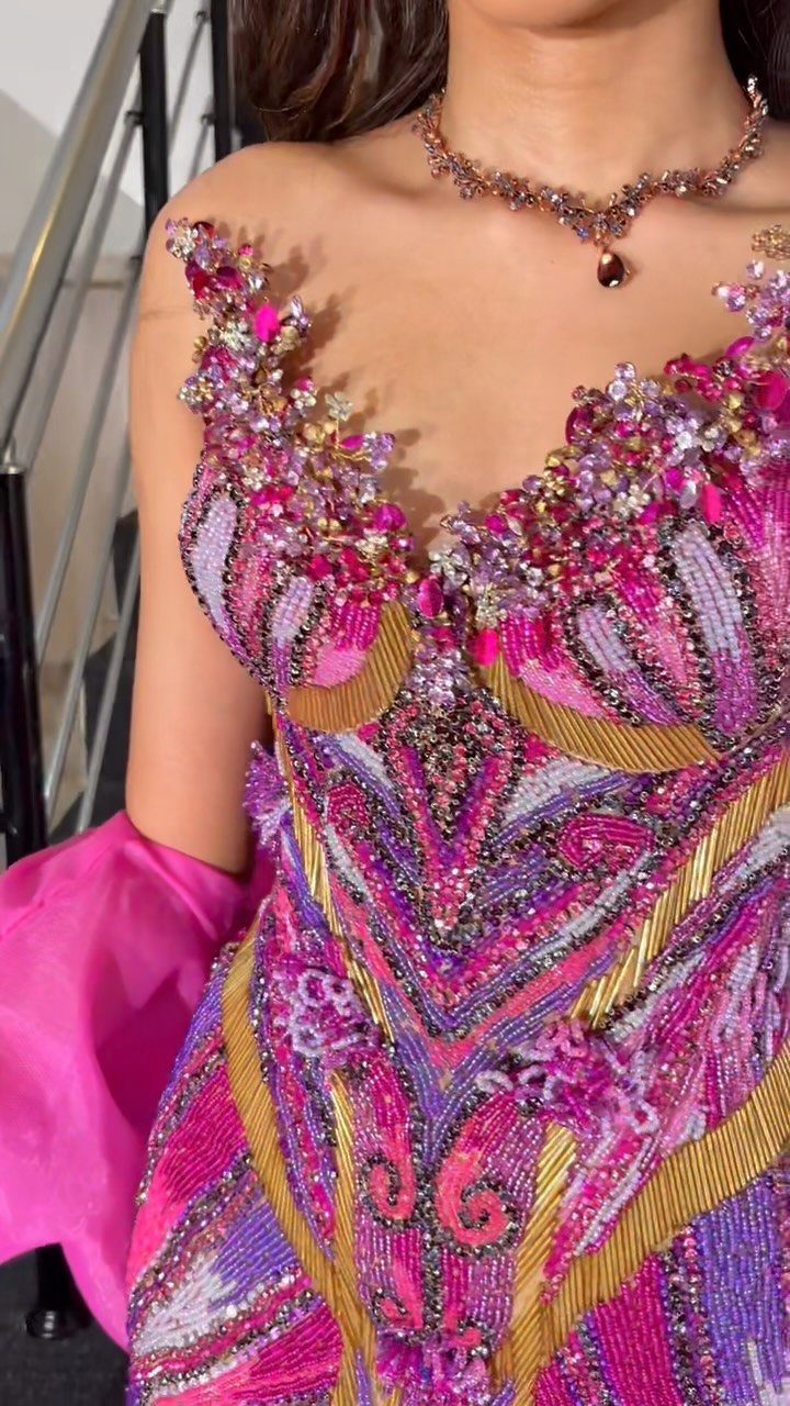 Beaded pink and purple prom dress with intricate gold patterns and matching necklace.