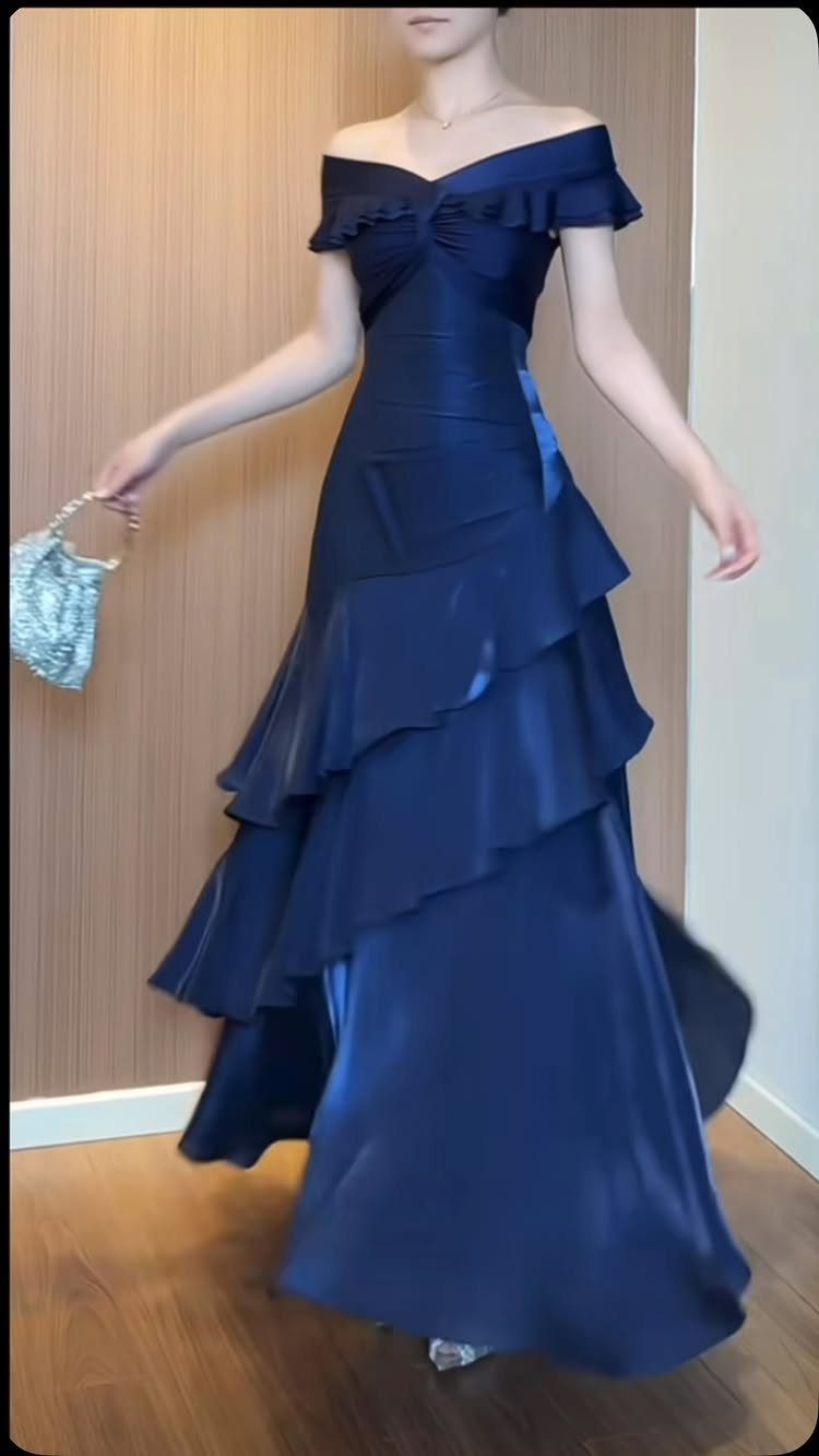 Navy blue satin gown with off-the-shoulder neckline and tiered ruffles on the skirt.