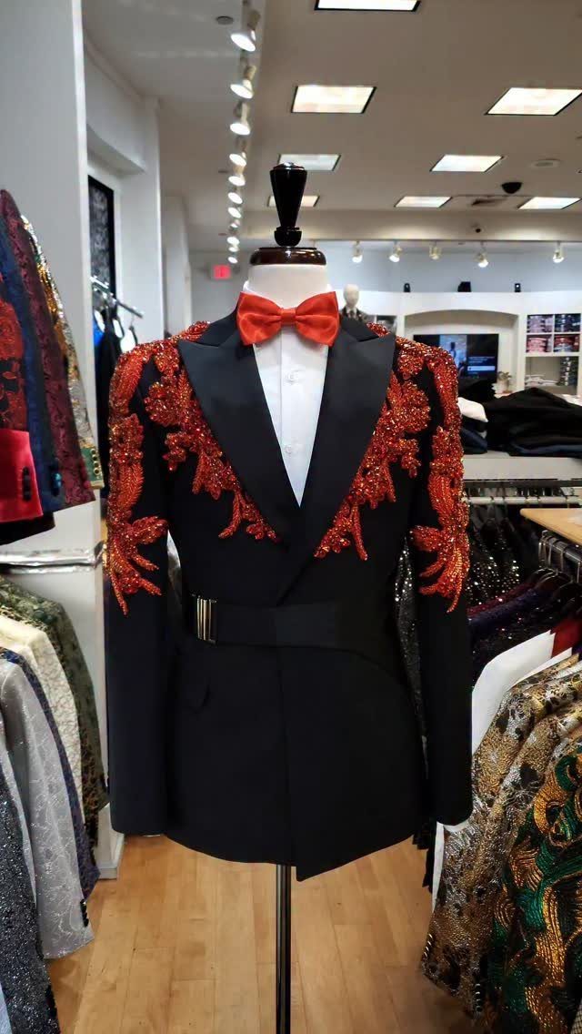 Black tuxedo jacket with red embroidery and red bow tie on a mannequin