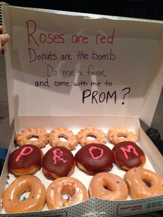 Open donut box with a handwritten prom proposal note on the inside lid.
