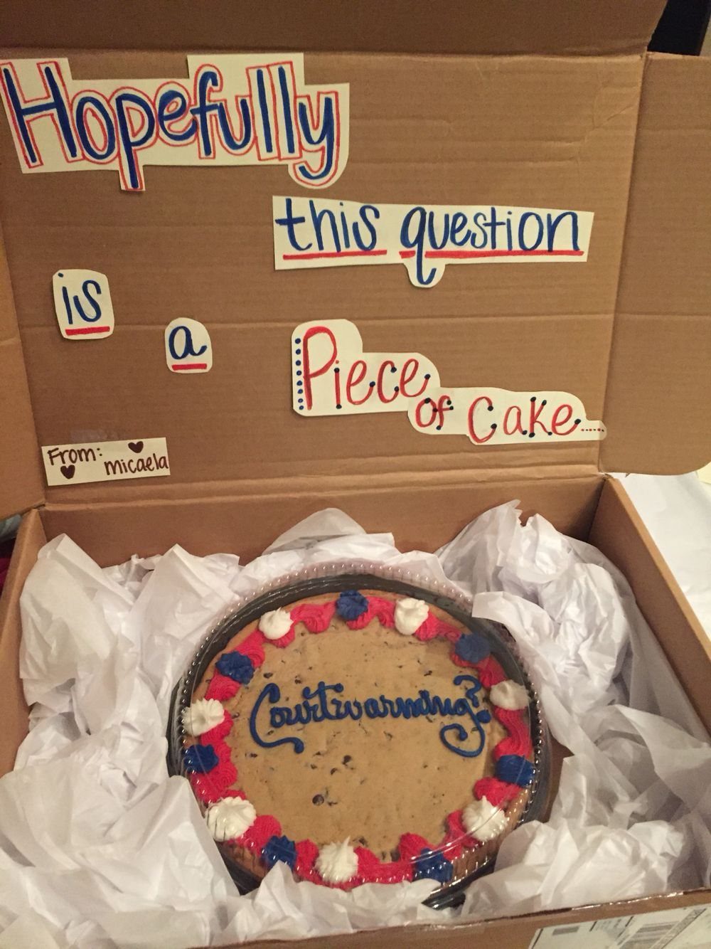 Large decorated chocolate chip cookie in a box with a promposal message.