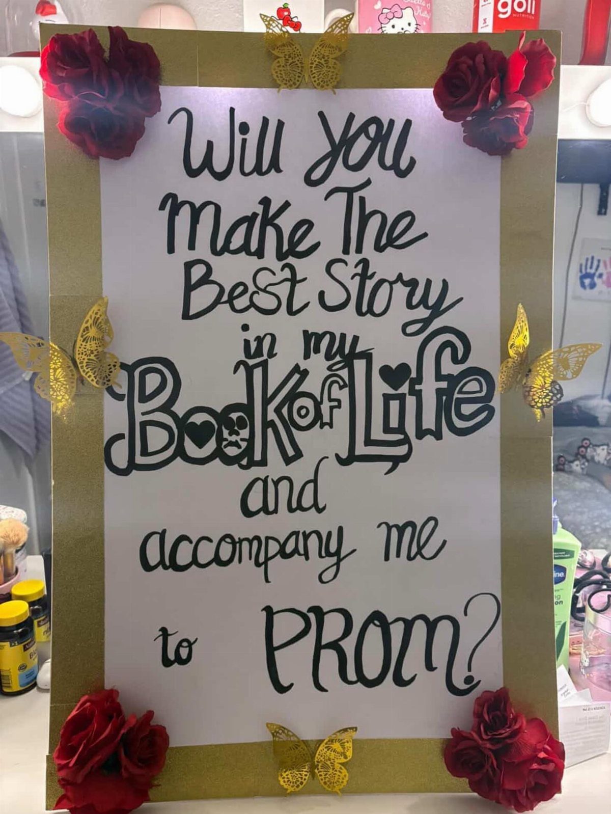 Prom proposal poster with gold border, red roses, and gold glittery butterflies.