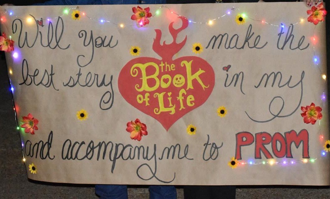 Large beige promposal poster with fairy lights, floral accents, and a red heart.
