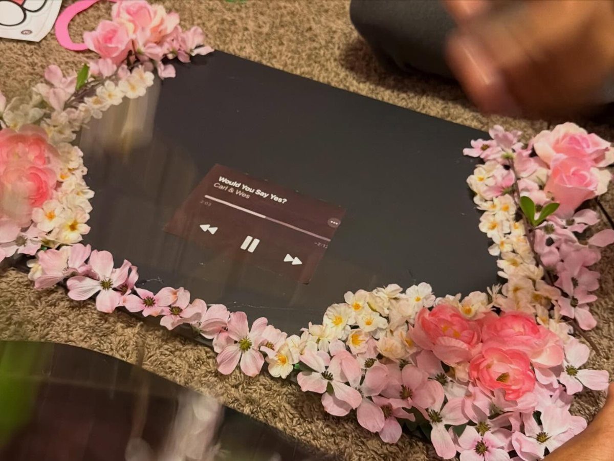 Prom proposal poster with a music player design framed by pink floral blossoms.