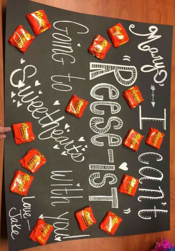 Black poster board with white chalk writing and orange Reese's candy cups.