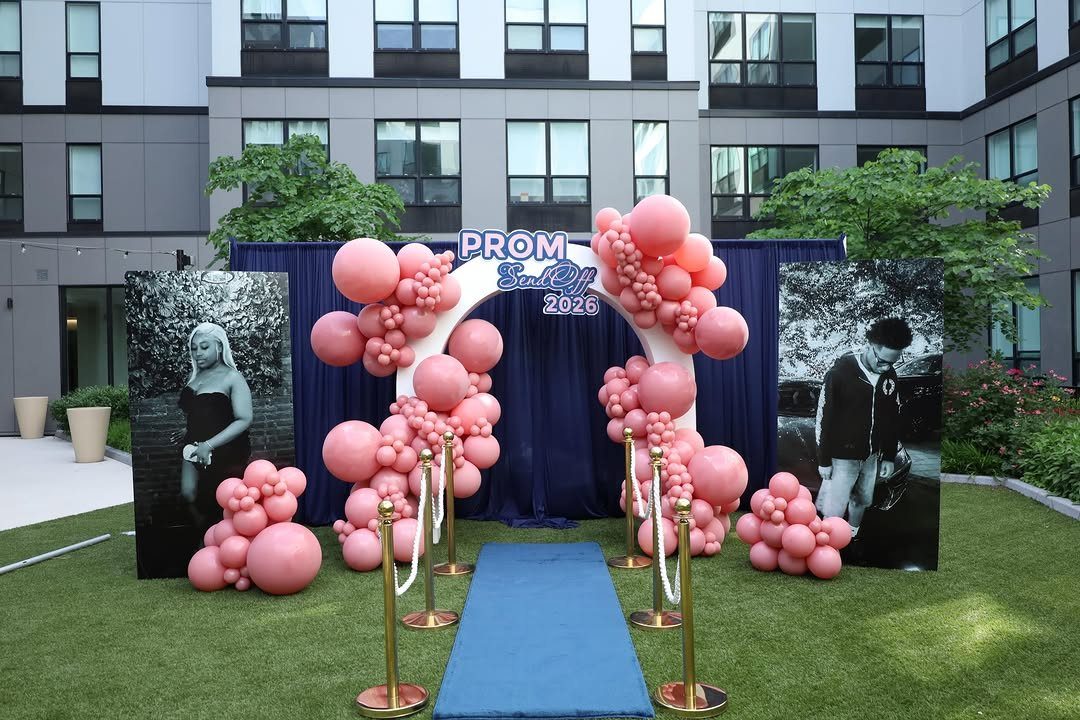 Pink balloon arch and blue carpet runner for a 2025 prom send-off event.
