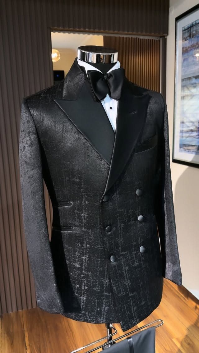 Black jacquard double-breasted tuxedo jacket with bow tie on a mannequin.