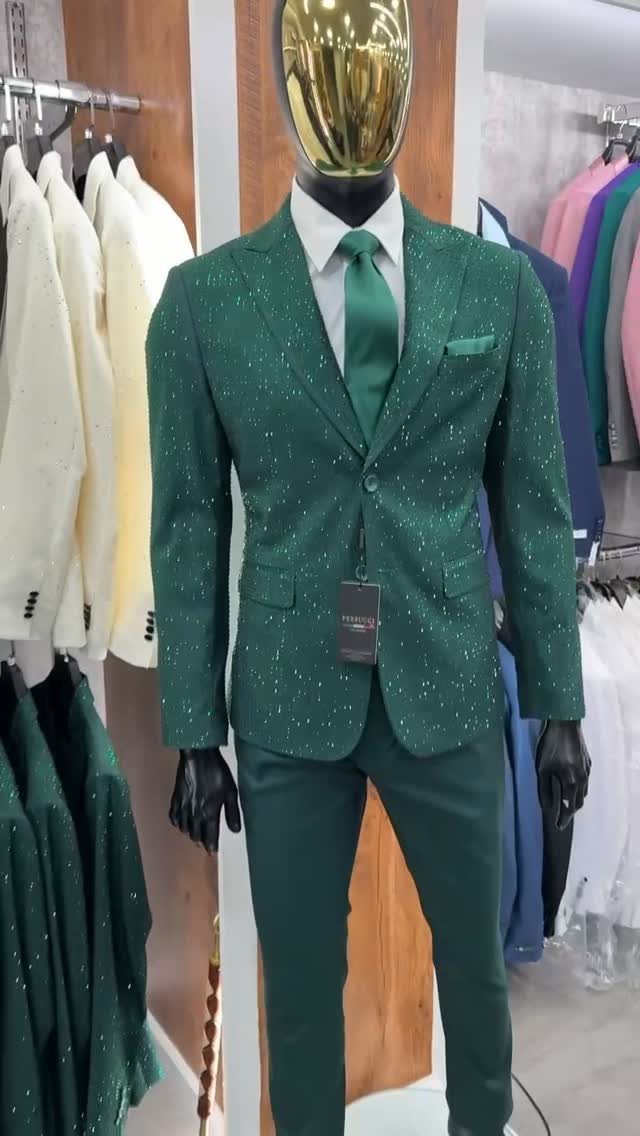 Emerald green sparkly suit with matching tie on a gold-headed mannequin.