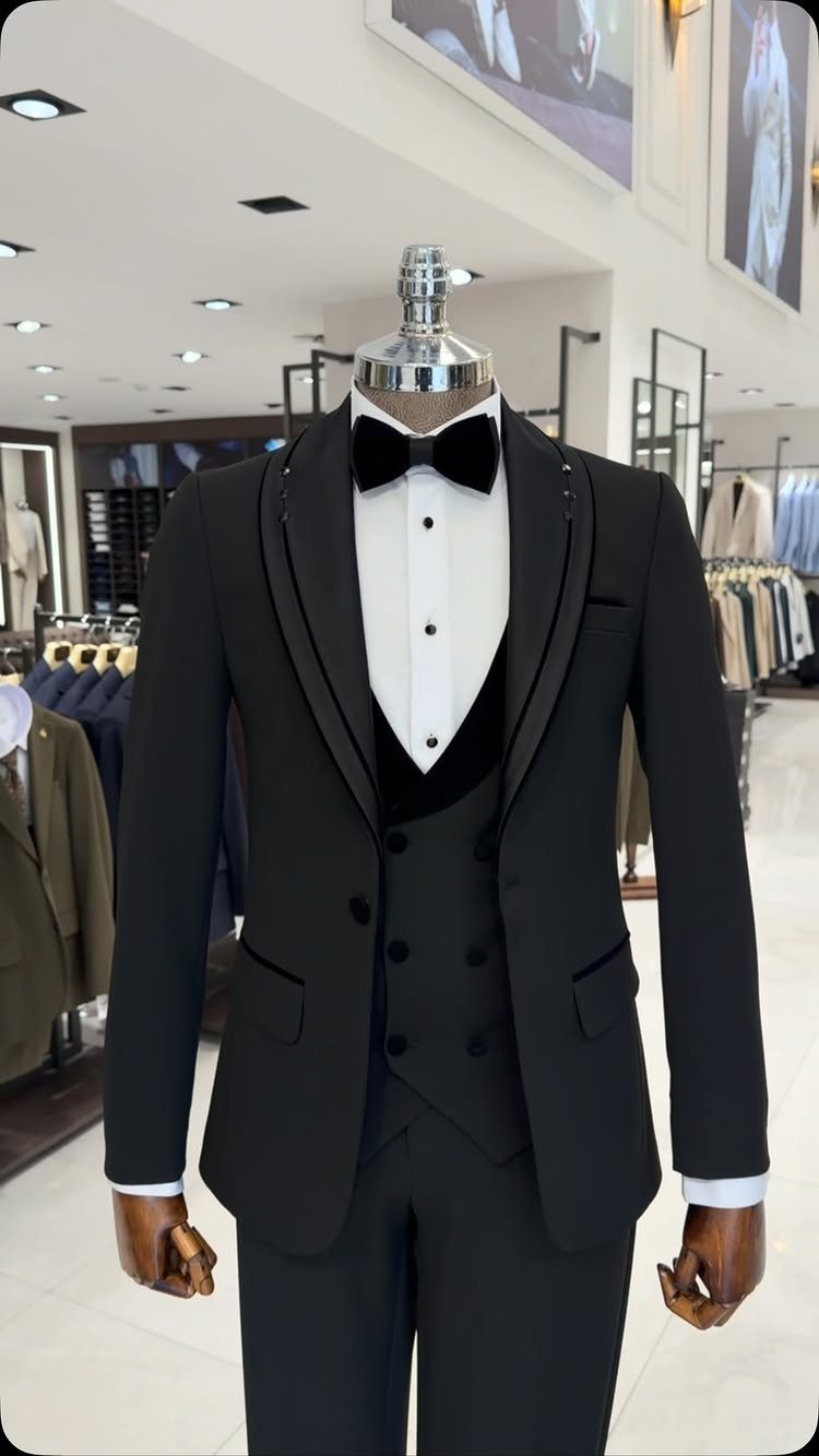 Black tuxedo with bow tie and waistcoat displayed on a store mannequin.