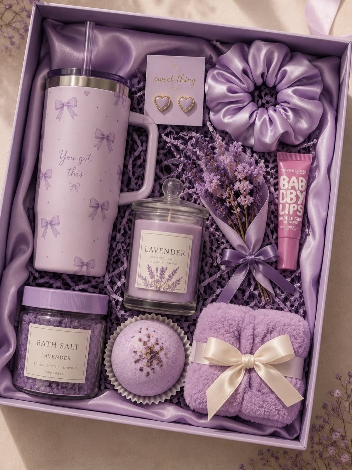 Lavender themed gift box with purple tumbler, candle, bath salts, and beauty accessories.