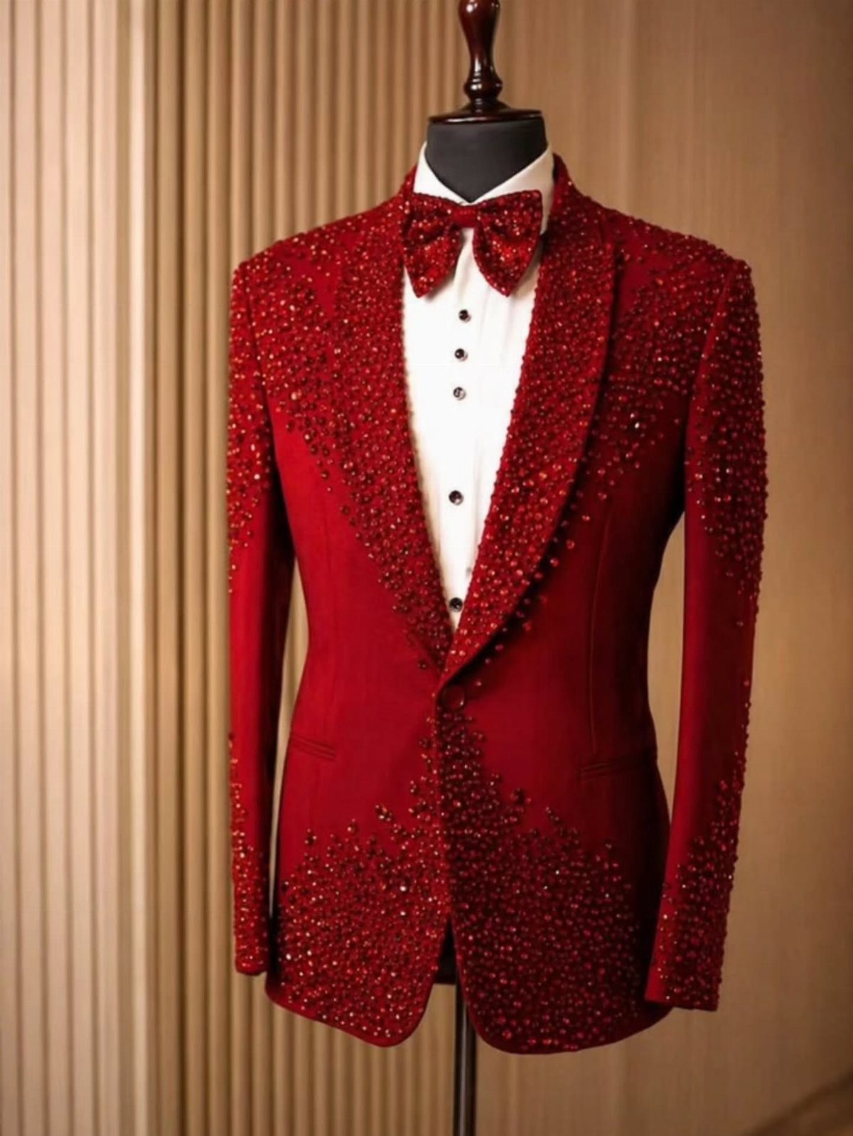 Red sequined tuxedo jacket with bow tie displayed on a black mannequin