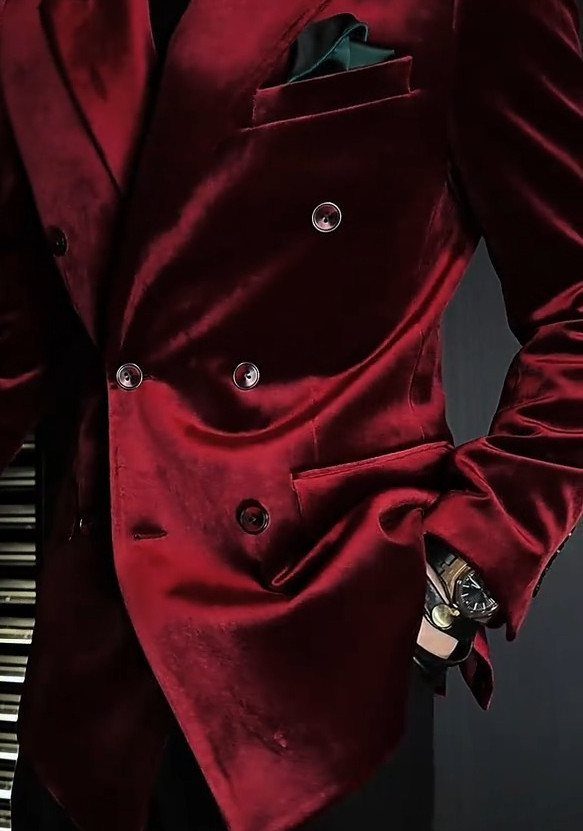 Red velvet double-breasted suit jacket with a dark pocket square and wrist watch.