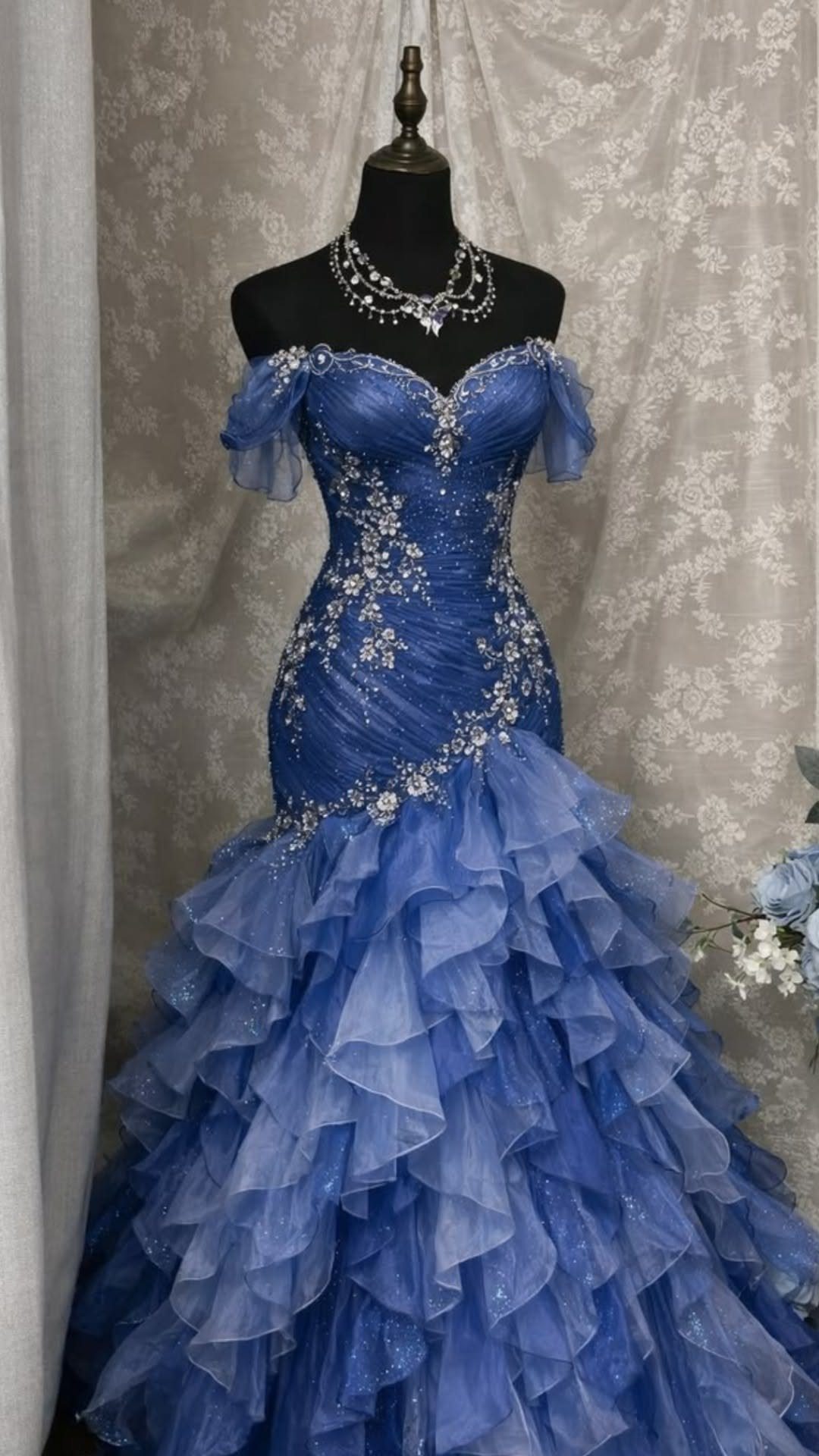 Royal blue off-the-shoulder gown with beaded bodice and ruffled skirt on a mannequin