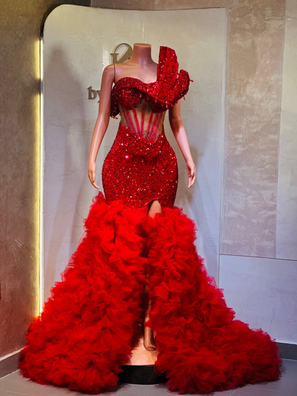 Red sequined mermaid gown with a one-shoulder ruffle and tiered ruffled skirt.