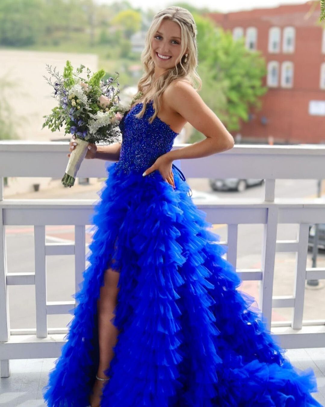 Woman in royal blue strapless gown with beaded bodice and ruffled tulle skirt