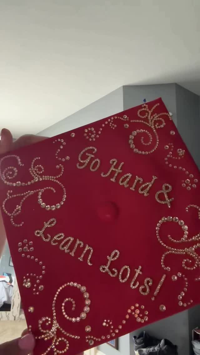 Red graduation cap decorated with gold rhinestones and the phrase Go Hard & Learn Lots!