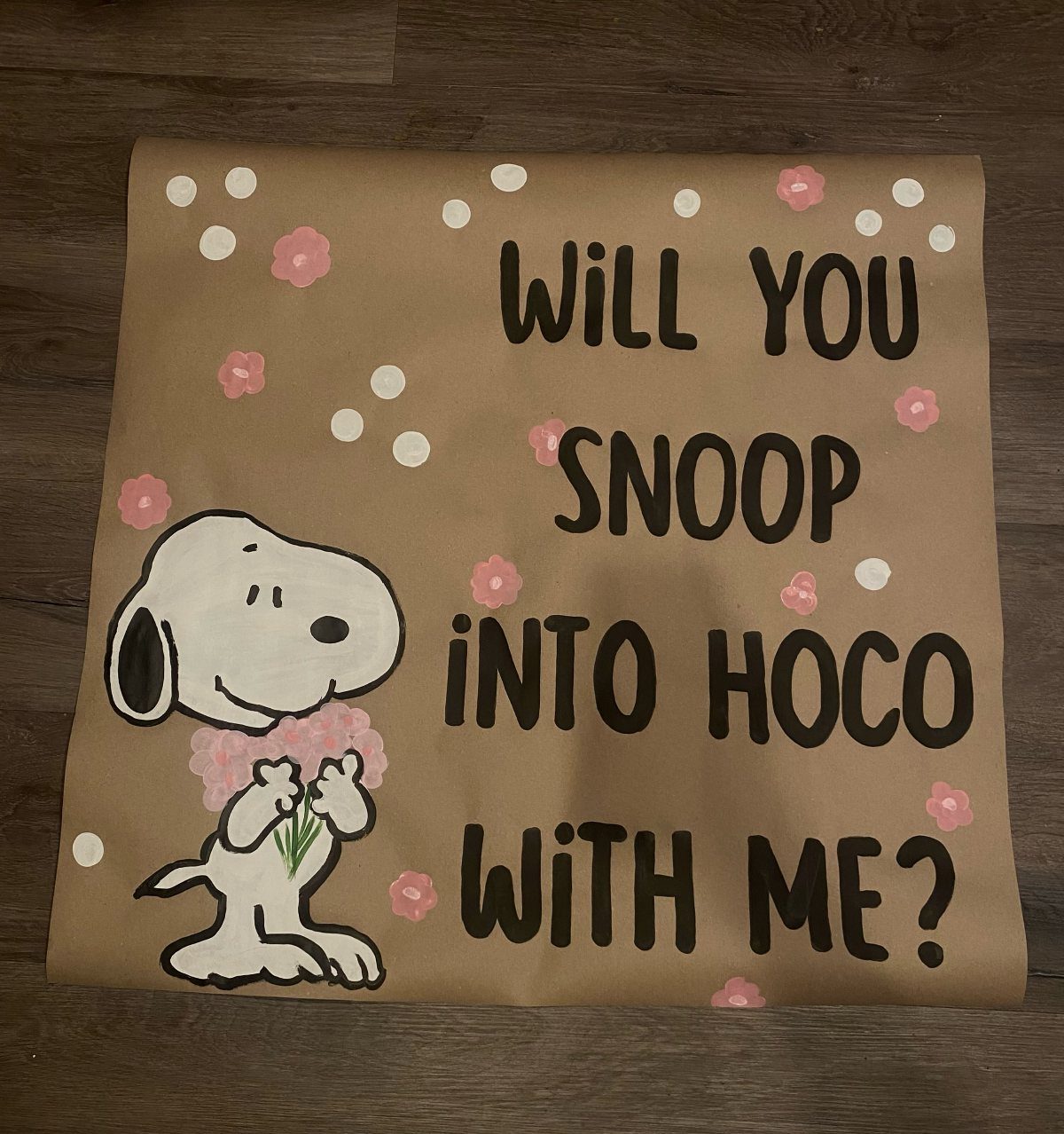 Brown homecoming proposal poster with Snoopy illustration and pink flower decorations.